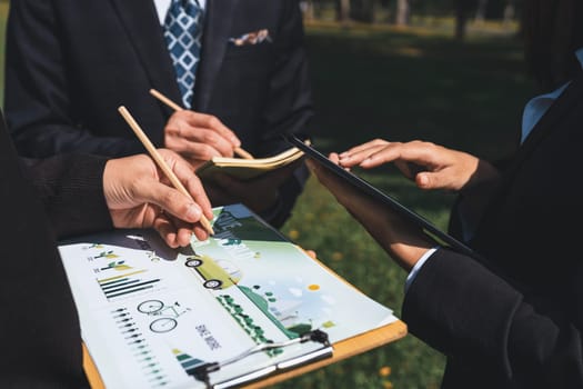 Group of asian business people presenting environmentally friendly development plan and sustainable technology project for greener future, establishing outdoor eco business office at natural park.Gyre