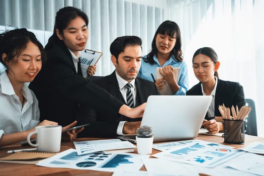 Diverse group of business analyst team analyzing financial data report paper on office table. Chart and graph dashboard by business intelligence analysis for strategic marketing planning Habiliment