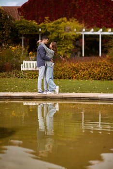 lovely young couple kissing outdoors in autumn. Loving couple walking in nature. Autumn mood. Happy man and woman hugging and kissing in autumn. Love. Fashionable couple outdoors. Fashion, people and lifestyle. Stylish couple in autumn outfit.