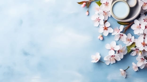 Gorgeous spring cherry branches adorned with delicate white flowers set against a soft light blue background. Petals gently falling, welcoming the beauty of spring. Ample copy space.