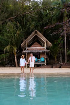 A wooden bamboo hut bungalow on the beach with palm trees. a young couple of men and women on a tropical Island in Thailand on a vacation, Koh Wai Island Trat Thailand