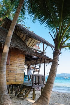 Koh Wai Island Trat Thailand is a tinny tropical Island near Koh Chang. wooden bamboo hut bungalow on the beach. a young couple of men and woman on a tropical Island in Thailand