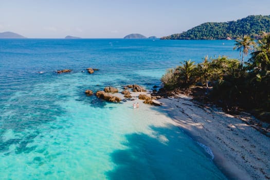 Drone aerial view at Koh Wai Island Trat Thailand is a tinny tropical Island near Koh Chang. a young couple of men and women on a tropical beach with a turqouse colored ocean