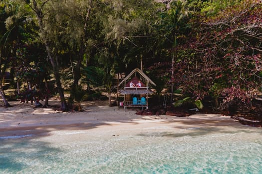 Koh Wai Island Trat Thailand near Koh Chang. wooden bamboo hut bungalow on the beach with a turqouse colored ocean. a young couple of men and woman on a tropical Island in Thailand