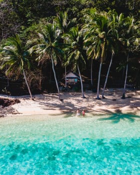 wooden bamboo hut bungalow on the beach with a turqouse colored ocean. a young couple of men and woman on a tropical Island in Thailand on vacation, Koh Wai Island Trat Thailand