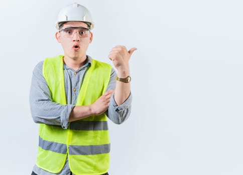 Portrait of surprised engineer man pointing side. Amazed engineer pointing advertising to side isolated. Construction worker pointing at an advertisement side