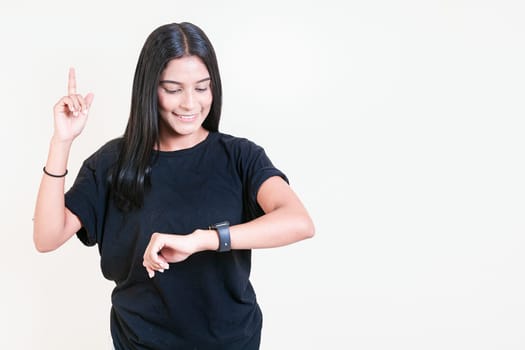 Happy latin girl looking at hand watch isolated. Smiling teen girl looking at hand watch isolated