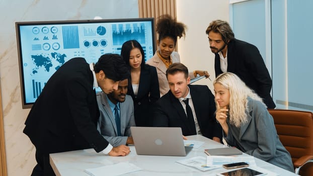 Analyst team utilizing BI Fintech to analyze financial data at table in ornamented meeting room. Businesspeople analyzing BI dashboard power for business insight and strategic marketing planning.