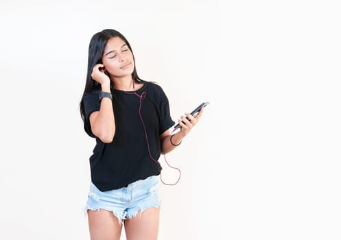 Attractive girl enjoying music with phone isolated. Happy latin gir listening to music with cell phone isolated. Portrait of beautiful girl listening to music with smartphone isolated