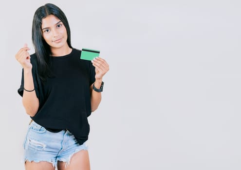 Girl holding credit card making money gesture with fingers isolated, looking at camera