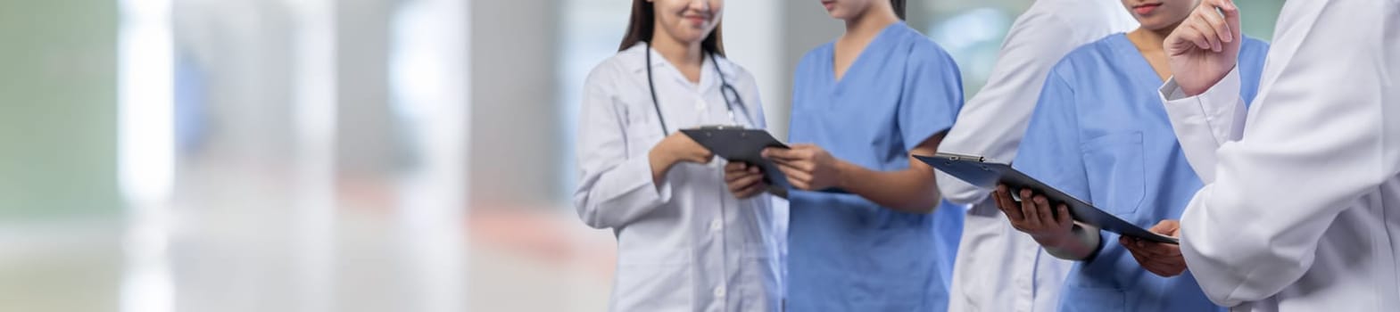 Medical staff team with doctor nurse and specialist working together with laptop and tablet on blur hospital corridor background. Medical and healthcare community in panoramic banner. Neoteric