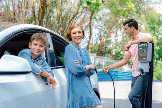 Family road trip vacation with electric vehicle, lovely family recharge EV car with green and clean energy. Natural and eco friendly car travel for sustainable environment. Perpetual