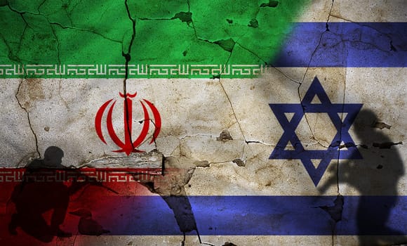 Israel vs Iran flag on cracked wall. Conflict between Iran and Israel concept. Political tension between Iran and Israel