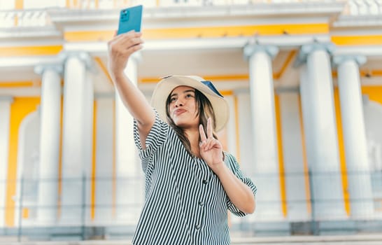 Beautiful tourist girl taking selfie in the cathedral of Granada. Young tourist woman with hat taking selfie in a square. Selfies and vacation concept