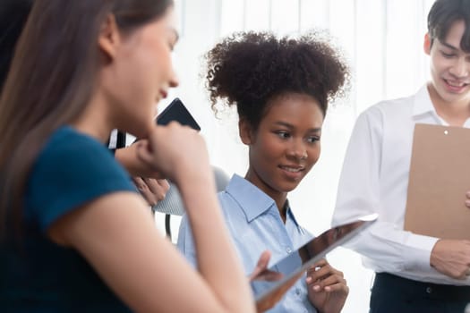 Young african businesswoman working together and discussing in corporate office with multicultural coworkers. Professional and diversity teamwork discuss business plan on desk. Concord