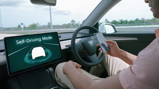 Self driving car or autonomous vehicle travel on speed highway with driverless system and autopilot mode allowing man driver relax and focus on smartphone without compromising safety. Perpetual