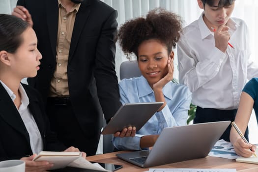 Happy diverse business people work together, discussing in corporate office. Professional and diversity teamwork discuss business plan on desk with laptop. Modern multicultural office worker. Concord