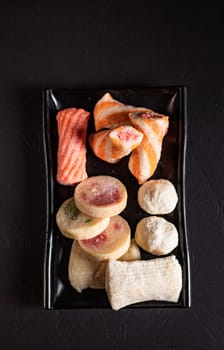 sliced ingredients in a flat black plate on a white background