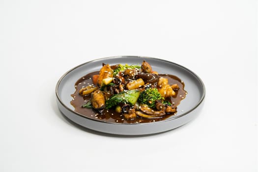 fried Asian dish with sweet and sour sauce, garlic and vegetables on a plate