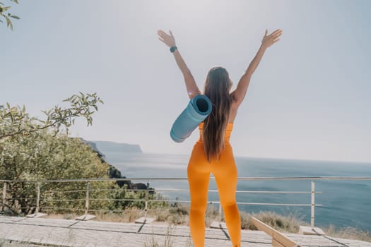 Fitness woman sea. Outdoor workout on yoga mat in park near to ocean beach. Female fitness pilates yoga routine concept. Healthy lifestyle. Happy fit woman exercising with rubber band in park.