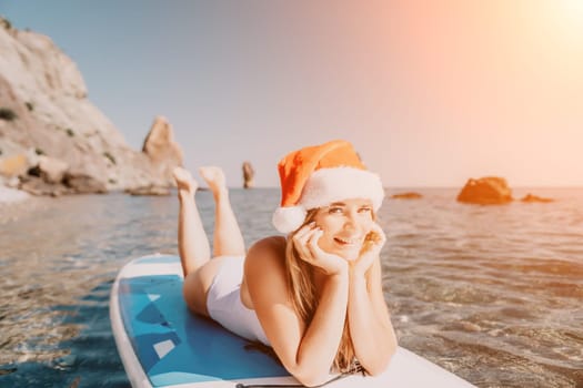 Close up shot of happy young caucasian woman looking at camera and smiling. Cute woman portrait in bikini posing on a volcanic rock high above the sea