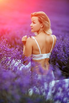 Woman lavender field. A middle-aged woman sits in a lavender field and enjoys aromatherapy. Aromatherapy concept, lavender oil, photo session in lavender.