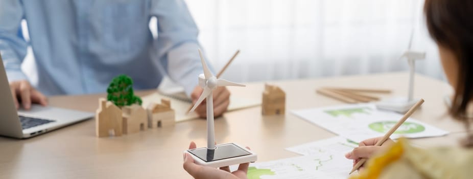 Businesswoman interested in investing in renewable energy at meeting table with environmental document scatter around. Business team discussion about green business project. Closeup. Delineation.