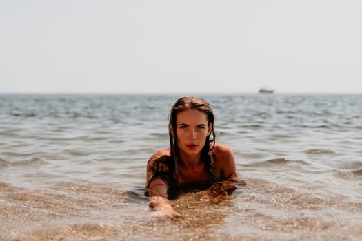 Woman travel sea. Young Happy woman in a long red dress posing on a beach near the sea on background of volcanic rocks, like in Iceland, sharing travel adventure journey