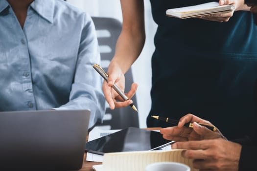 Diverse business people work together, discuss in corporate office. Professional teamwork discussing and pointing at laptop. Modern multicultural office worker. Concord