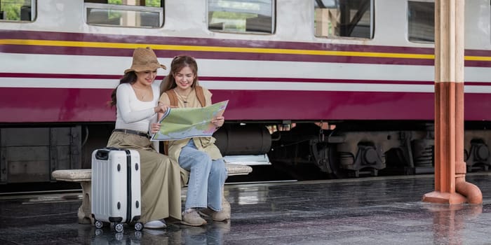 Travel concept. girl friend wear hat holding map have bag and luggage. female traveller waiting train at train station.