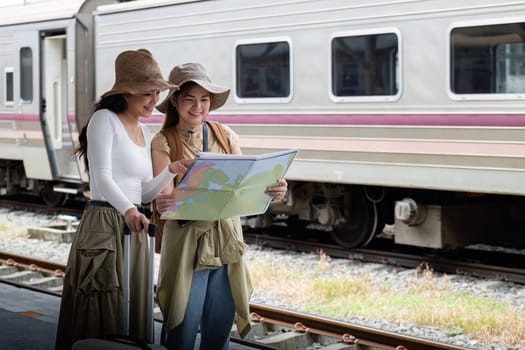 Travel concept. girl friend wear hat holding map have bag and luggage. female traveller waiting train at train station.