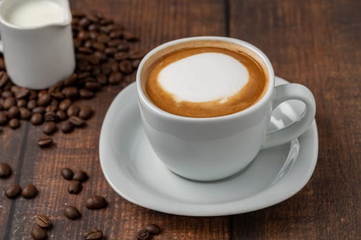 Relaxing latte coffee in white porcelain cup on wooden table