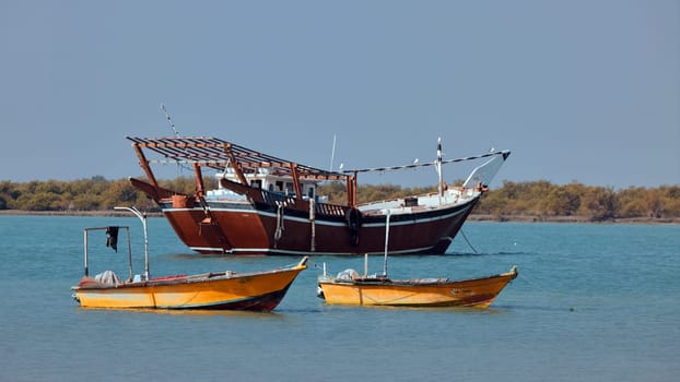 Traditional Dhow old wooden boat in the harbor of Iranian Qeshm Island. Tradition Lenj Fishing Boat in Qeshm Island in Southern Iran. Old wooden stealth smuggler's ship.
