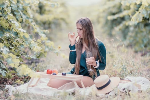 Picnic and wine tasting at sunset in the hills of Italy, Tuscany. Vineyards and open nature in the summer. Romantic dinner, fruit and wine.