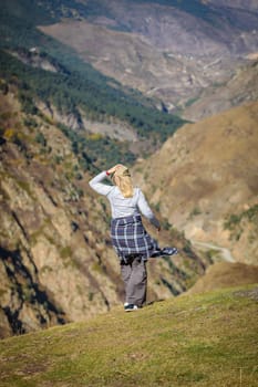 Cute girl enjoying the majesty of the mountainous landscape, feeling all the beauty of the surrounding nature