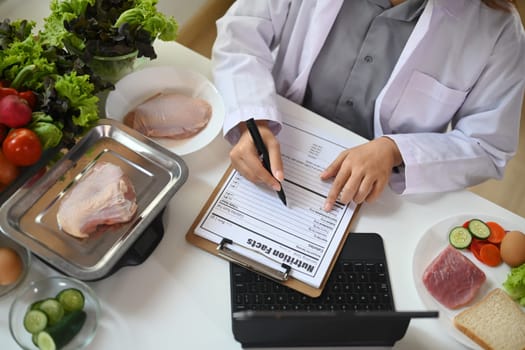 Nutritionist working in her office various healthy products. Healthy eating and nutrition concept.