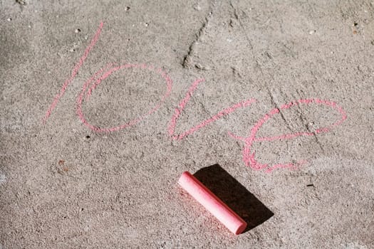 The word love written on the asphalt with chalk