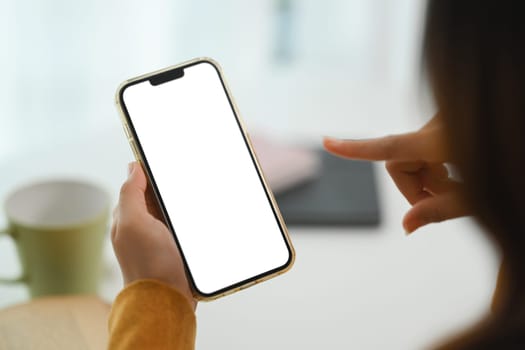 Closeup woman hands holding mobile phone with empty screen for advertising or message.