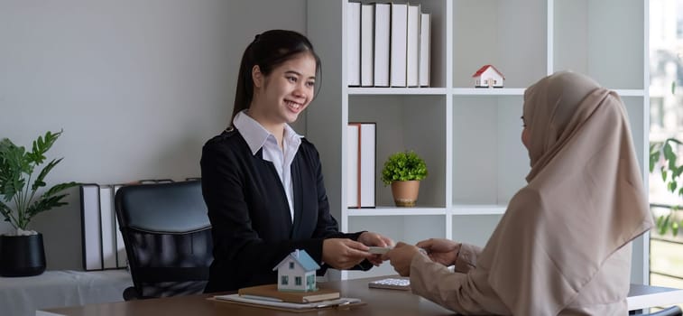 A real estate agent offers a house to a female Muslim client. The concept of buying and selling houses and real estate..