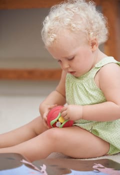 Baby, child and girl play with toys in home, adorable and cute kid alone in house. Young blonde toddler, game and childhood development for learning, education and innocent in kindergarten nursery.