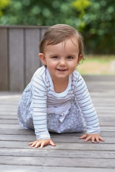 Baby girl, crawling outside and portrait on floor, child development and growth with sensory coordination. Girl, cognition and healthy in good mood, childhood or balance with arms, kid or adorable.