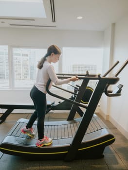 A dedicated young athlete giving her all, running on a treadmill in the gym.