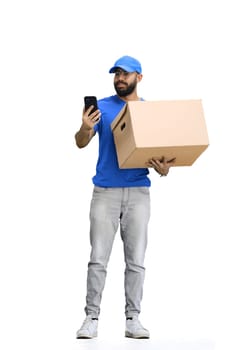 A male deliveryman, on a white background, in full height, with a box and a phone.