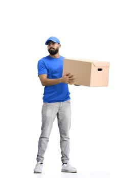 A male deliveryman, on a white background, in full height, shakes a box.