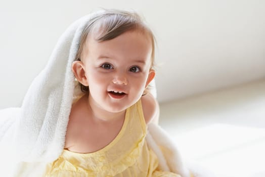 Baby, girl and blanket in portrait at home, child development and curious for childhood. Female person, healthy kid and sweet or comfort at house, peaceful and playing on floor or relaxing for growth.