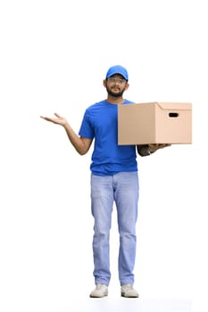 A male deliveryman, on a white background, full-length, with a box, points to the side.