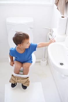 Boy child, potty training and toilet paper with sitting, diaper and thinking for learning, development or progress. Kid, family home and back in bathroom with tissue, hygiene or solution with nappy.