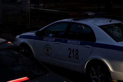 BELARUS, VITEBSK - OCTOBER 21, 2019: White police car in the dark on the road