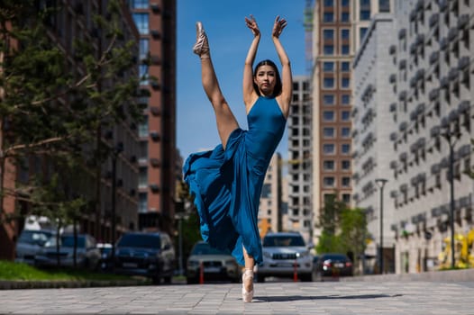 Beautiful Asian ballerina dancing outdoors. Urban landscape