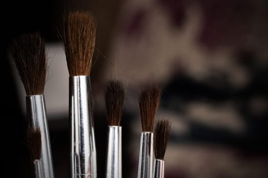 Paint brushes close up on a dark background, copy space
